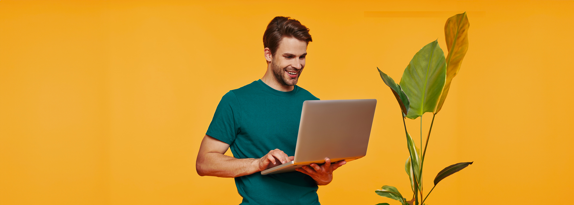 Handsome Young Man Casual Clothing Using Laptop Smiling While Standing Against Yellow Wall
